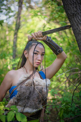 Beautiful asian woman with the dagger is hunting in the forest concept.