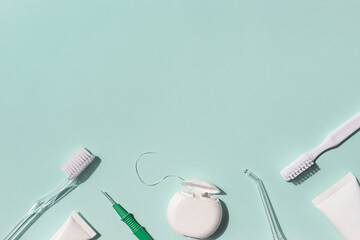 Dental care concept frame with toothbrush, irrigator, tooth floss and toothpaste on the blue...