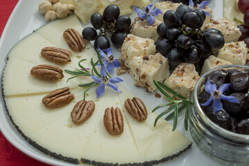 selection  of cheeses with grapes and edible flowers