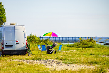 Umbrella with chairs at campervan on beach