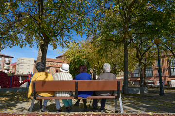 Four older ladies sitting on a park bench in Astorga