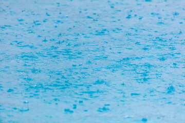 Surface of blue water in heavy rain.