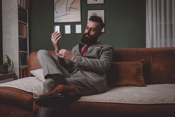 businessman in a grey suit and red tie buttoning sleeve