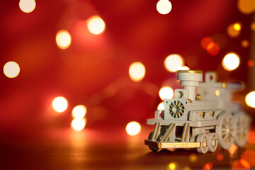 White Christmas locomotive on a red background with bokeh and defocused lights. Free space. Copy space. Background.
