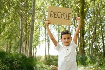 child displays message to recycle. Young activist concerned about ecology and nature conservation - obrazy, fototapety, plakaty