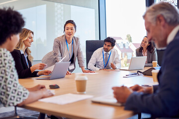 Businesswoman Leading Multi-Cultural Business Team Meeting And Collaborating Around Table In Office