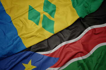 Fototapeta premium waving colorful flag of south sudan and national flag of saint vincent and the grenadines.