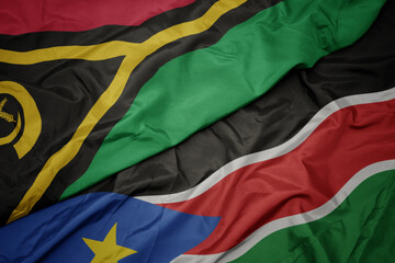 waving colorful flag of south sudan and national flag of Vanuatu .