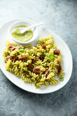 Pasta with pesto sauce and sun dried tomatoes