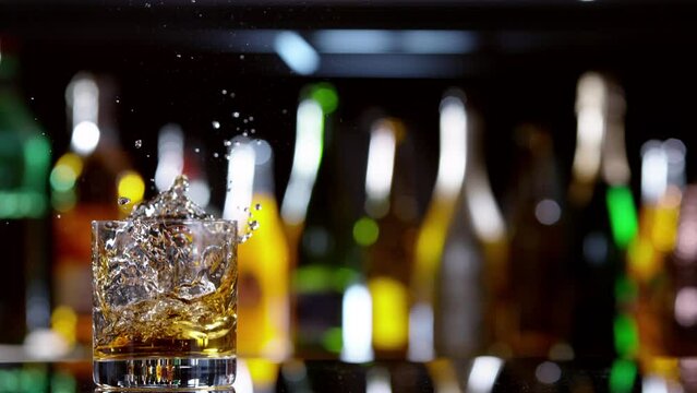 Super slow motion of falling ice cube into whiskey drink, camera motion. Speed ramp effect. Filmed on high speed cinema camera, 1000 fps.