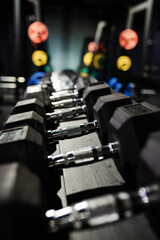Obraz na płótnie Canvas Black dumbbell set. Close up many metal dumbbells on rack in sport fitness center , Weight Training Equipment concept.