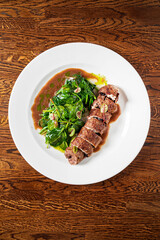 beef with roasted spinach on the wooden background
