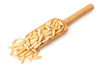 Roasted pine nuts in the wooden scoop, isolated on white background.