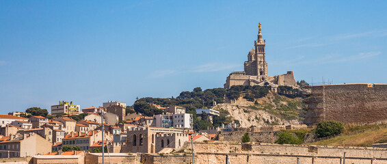 Notre-Dame de la Garde church seen from a boat sailing on the mediterranean sea in Marseille, France