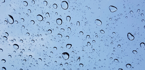 Water droplets perspective through window glass surface against blue sky good for multimedia content