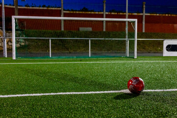 A soccer ball in front of the goal is ready to hit the goal.