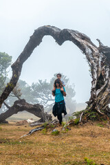 Fanal forest with fog in Madeira, having fun with the child in the arms in an arch, laurel trees