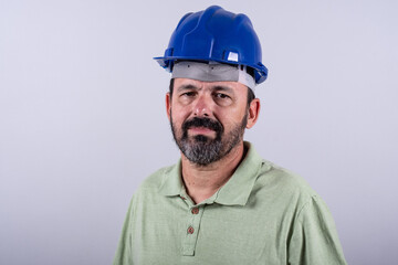 Portrait of happy mature architect in helmet standing male industrial inspector, 60s wearing shirt posing in studio.