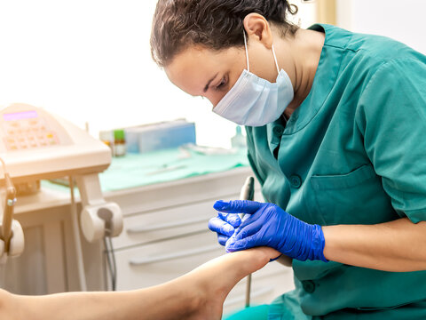 Female podiatrist doing chiropody in her podiatry clinic. Selective focus