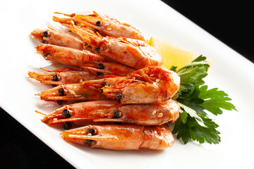 Fried shrimp in a bowl. On a dark background.