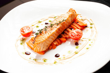 Grilled salmon steak in a bowl. On a dark background.