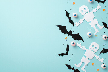 Halloween decorations concept. Top view photo of skeleton bat silhouettes spooky eyeballs and confetti on isolated light blue background with empty space