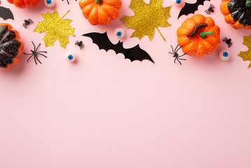 Halloween creepy decorations concept. Top view photo of pumpkins gold sparkle leaves eyes insects...
