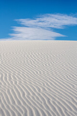 Fototapeta na wymiar Flat Cloud Crests Over White Sand Dune With Ripple Texture