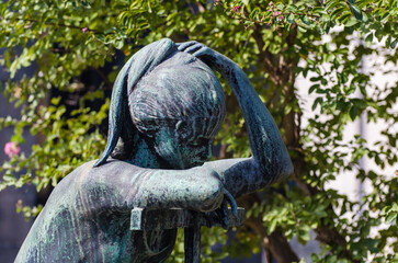 Obraz premium La statua bronzea di una donna dolente su una tomba del cimitero maggiore di Milano