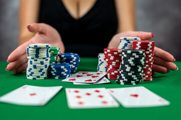 young woman is successfully gambling in a casino at table with cards chips and alcohol close-up