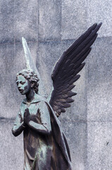 La statua brozea di un angelo su una tomba dell cimitero maggiore di Milano