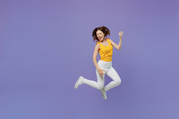 Fototapeta na wymiar Full body expressive singer happy young woman she wear yellow tank shirt jump high play guitar hand gesture isolated on plain pastel light purple background studio portrait. People lifestyle concept.