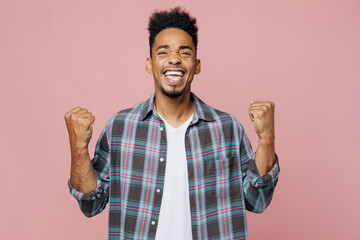 Young smiling happy man of African American ethnicity 20s he wear blue shirt doing winner gesture...