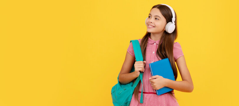 happy school child in headphones carry backpack and workbook, ebook. Banner of schoolgirl student. School child pupil portrait with copy space.