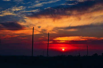 Obraz premium Dramatic sunset on the outskirts of the village. Evening