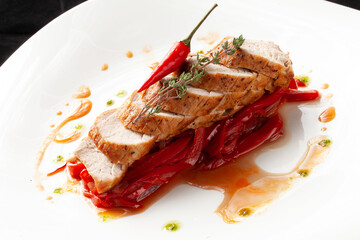 Cooked chicken breast in a bowl. On a dark background.