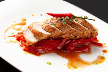 Cooked chicken breast in a bowl. On a dark background.