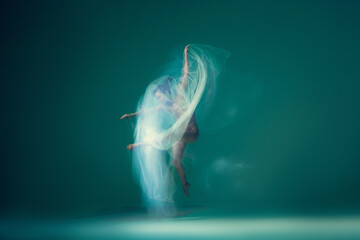 Solo. Beautiful and graceful ballet dancer dancing with white transparent cloth, isolated on cyan...