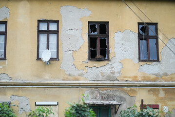 Fototapeta na wymiar Homeless flats with broken windows and ugly wall