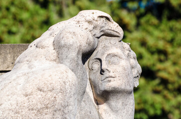 Fototapeta na wymiar La statua di marmo di un uomo con un’aquila su una tomba del cimitero maggiore di Milano