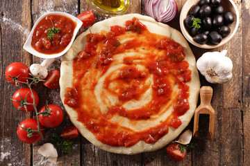 raw dough pizza with tomato sauce and ingredients