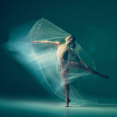 Graceful ballet dancer dancing with white cloth, fabric isolated on green background. Art, motion,...