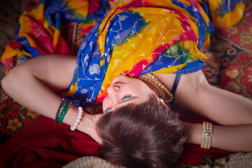 A beautiful European girl with short hair looking like an Arab woman in a red room in a harem....