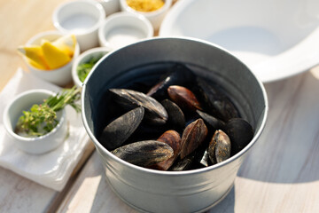Mussels shells in bucket on wooden background.