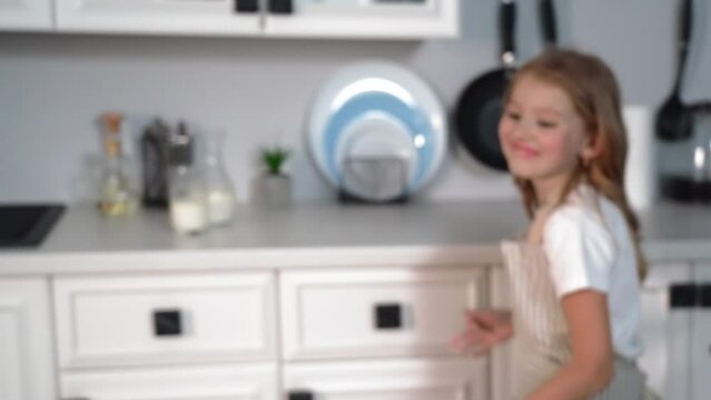 happy pastime, girl cheerfully runs around kitchen while making homemade flour cookies at home