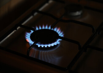 Natural Gas is burning in gas-stove in the kitchen. Concept for problems with natural gas in Europe.