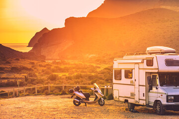 Scooter at camper camping on mountain nature at sunset. - obrazy, fototapety, plakaty