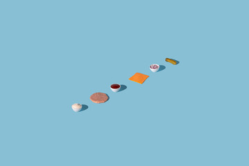 Pattern made from food and ingredients for a burger. Mayonnaise, beef, ketchup, cheese, onion and pickle on a pastel blue background. Minimal concept. Creative idea.