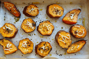 grilled vegetables sweet potato slices on baking paper on baking sheet sprinkled with spices