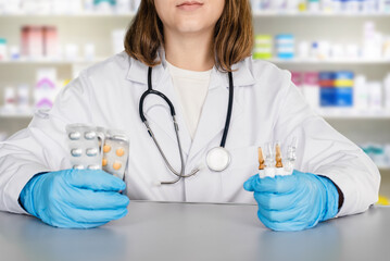 Female pharmacist working in chemist shop and holding medication